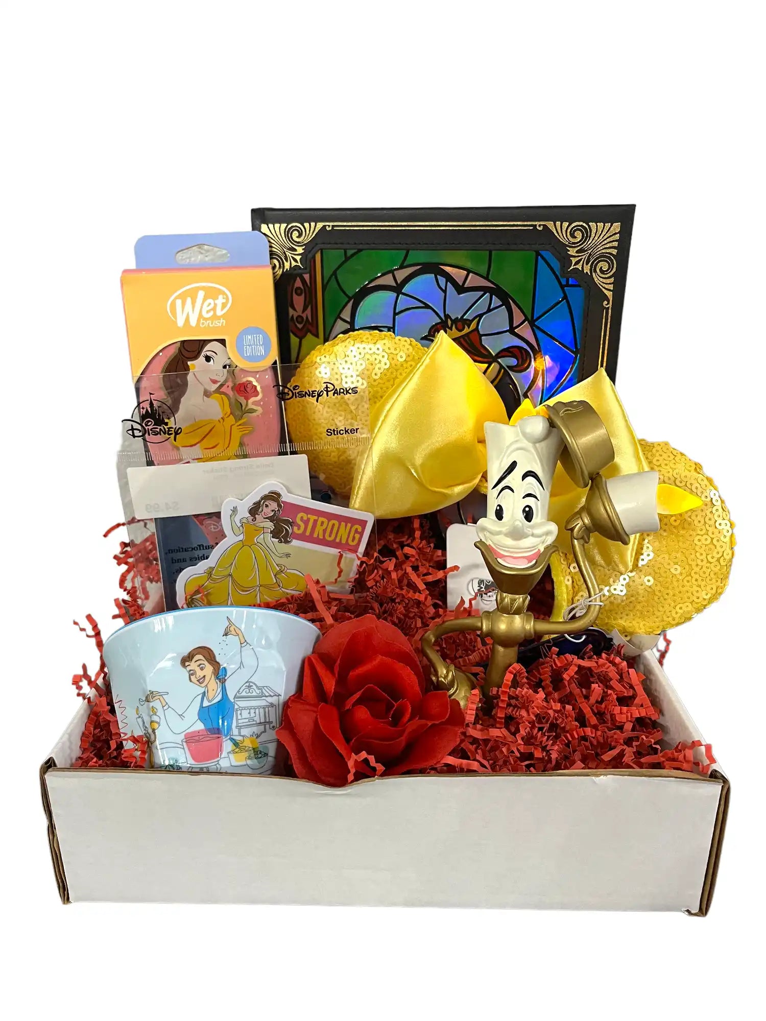 A ’Beauty and the Beast’ themed gift box filled with various merchandise, including a mug, stickers, bath bombs, and a Lumiere figurine.