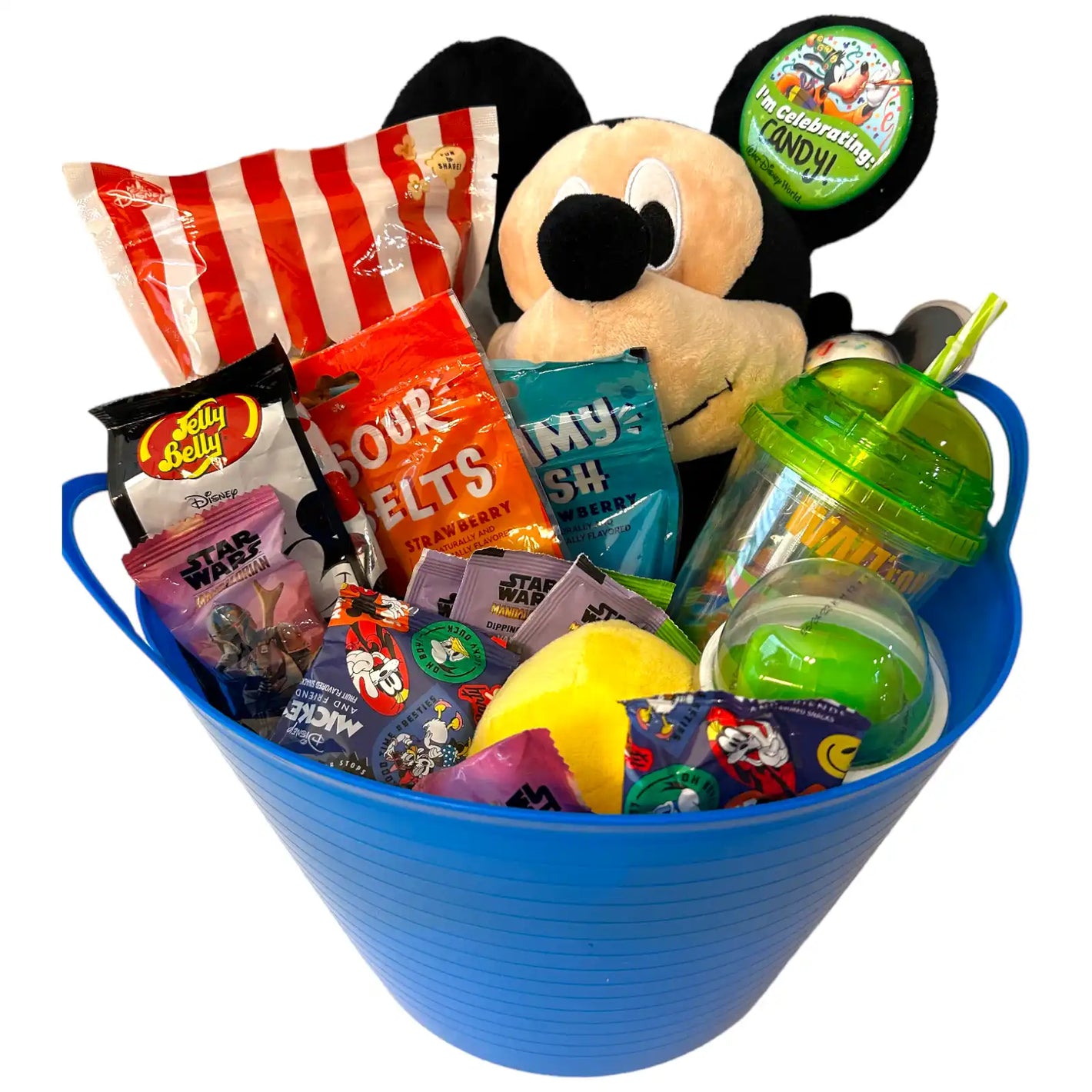 A blue bucket filled with a Mickey Mouse plush toy, various candies, and a green sippy cup.